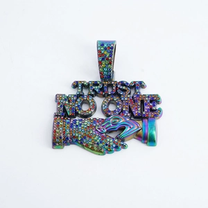Dettaglio del ciondolo Trust No One arcobaleno con cristalli e catena stile cubano