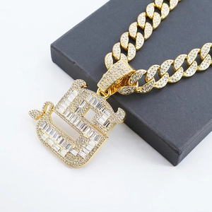 Nahaufnahme des goldenen Hip-Hop-Anhängers mit Zirkonia auf einer schwarzen Schmuckbox