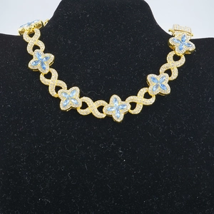 Dettaglio della collana dorata con pietre marquise blu e simboli dell'infinito intrecciati