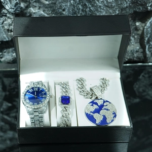 Close-up of luxury iced-out watch, cuban bracelet, and earth pendant set in a gift box