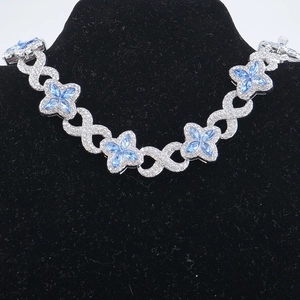 Dettaglio della collana hip-hop a quadrifoglio con gemme blu e cristalli scintillanti
