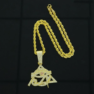 Detailed macro view of iced out Eye of Horus pendant on golden hip hop rope chain