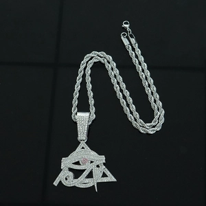 Macro detail of iced out hip hop pendant with Eye of Horus and pink center stone