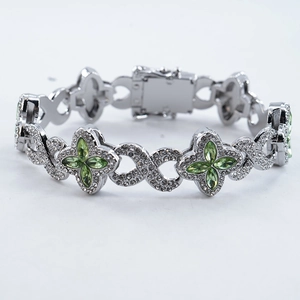 Silver infinity link bracelet with emerald green four-leaf clover pendant and zircon