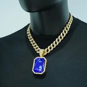 Detail of hip hop Cuban chain with large blue gemstone pendant and micro-pave crystals