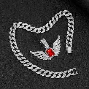 Detail van de hiphop engelenvleugel hanger met rode edelsteen op cubaanse schakelketting