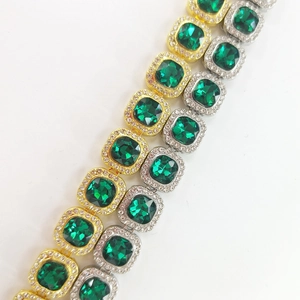 Detail of hip hop necklaces with square green gems in gold and silver plating