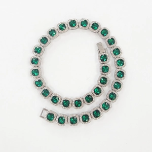 Macro detail of hip hop tennis chain featuring square green stones with white zircon halo