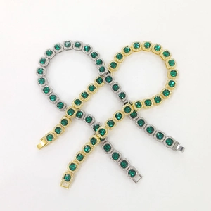 Detail of gold and silver hip hop necklaces with square green emerald cut crystals