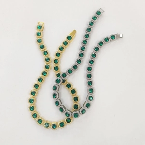 Macro view of emerald green square cut rhinestones on gold, silver and black chains