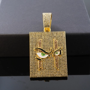 Vista macro del colgante cuadrado estilo hip hop con acabado dorado, pavé de diamantes y ojo verde