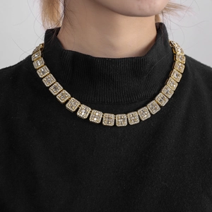 Macro shot of gold-plated iced-out cuban link chain with zircon stones on a model