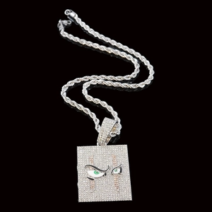 Primer plano del colgante hip hop cuadrado con piedras, ojo verde y cadena de cuerda