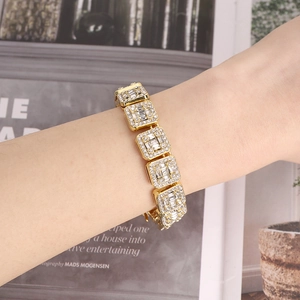 Close-up of golden Cuban link chain bracelet with micro-pave crystals on wrist