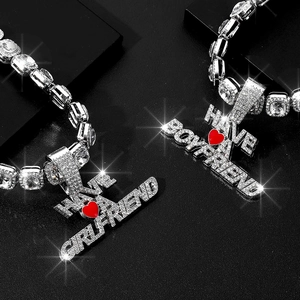 Détail de colliers de couple en argent avec pendentifs HAVE A BOYFRIEND/GIRLFRIEND givrés