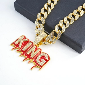 Dettaglio del ciondolo King dorato con smalto rosso e strass su una catena cubana da uomo hip hop