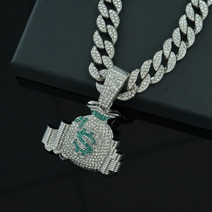 Detailed close-up of hip hop money bag pendant with green crystals on silver Cuban chain