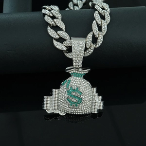 Macro view of iced out money bag pendant with green crystals on silver Cuban link chain