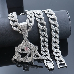 Macro shot of silver hip hop necklace featuring iced out Eye of Horus pyramid pendant