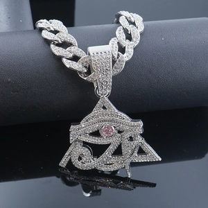 Macro shot of silver hip-hop pendant featuring Eye of Horus with pink rhinestone on Cuban chain
