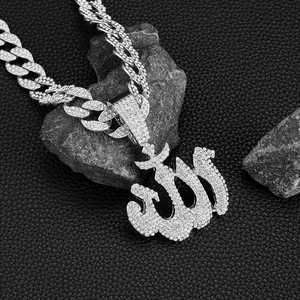 Dettaglio macro del ciondolo Allah con strass e catena cubana lucida su pietra scura