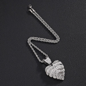 Dettaglio di un ciondolo a cuore argento con strass su una spessa catena a corda lucida