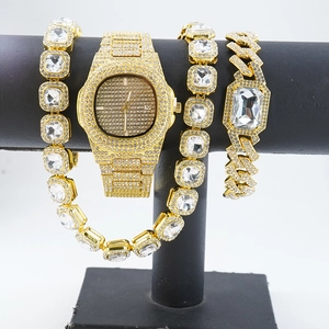 Luxury gold iced-out watch set with sparkling diamond bracelets on a display stand