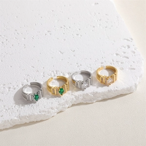 Detailed view of adjustable pear-cut emerald and white zircon rings on stone surface