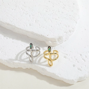 Close-up of gold and silver snake rings with black enamel heads and green zircon eyes