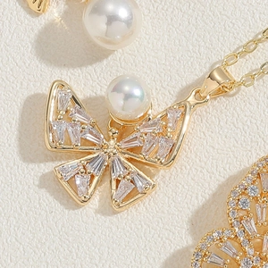 Vue macro du collier pendentif papillon avec oxydes de zirconium et incrustation perle