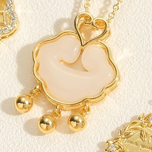 Detailed close-up of a vintage golden padlock pendant with white shell and mini bells