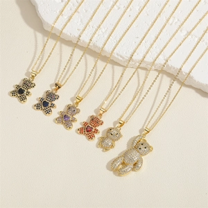 Chic gold-plated teddy bear pendant necklaces with colorful zircon stones on stone background