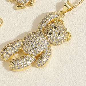 Macro detail of a teddy bear pendant necklace with sparkling white zircons and gold plating