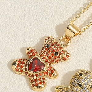 Detail of bear pendant necklace with red micro-pavé crystals and heart zircon