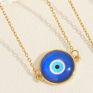 Detailaufnahme eines blauen Evil Eye Anhängers an einer feinen goldenen Titanstahlkette