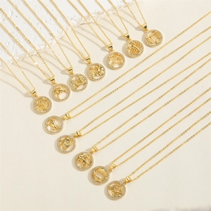 14K gold plated zodiac sign necklaces with cubic zirconia pendants on white textured stone