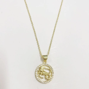 Macro view of 14K gold plated Capricorn zodiac pendant necklace with white zircon stones