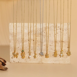 Collection of gold and silver animal pendant necklaces with pearls on stone pedestals