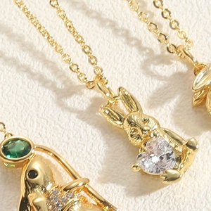 Macro shot of gold rabbit pendant necklace with sparkling heart-shaped zircon crystal