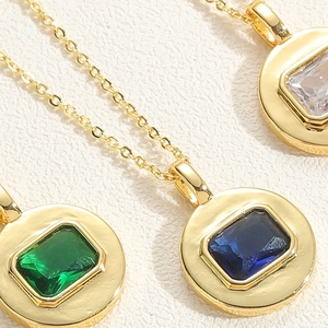 Close-up of geometric square zircon pendants in gold settings on O-chains for women