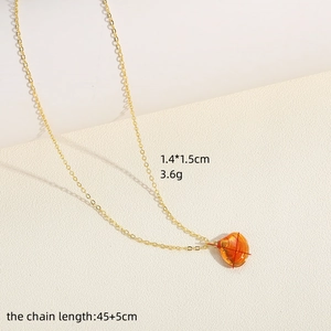 Detail van een oranje schelphanger aan een gouden ketting van 45+5 cm