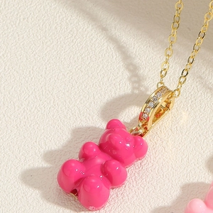 Macro detail of gummy bear pendant with rose pink resin and gold zircon clasp