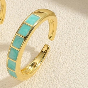 Détail macro d'une bague en argent S925 plaqué or avec incrustation d'émail vert sarcelle
