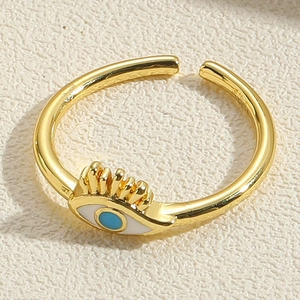 Macro d'une bague œil protecteur dorée avec émail bleu et détails fins de cils