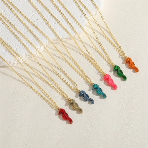 Macro shot of colorful seahorse pendant necklaces with detailed gold link chains
