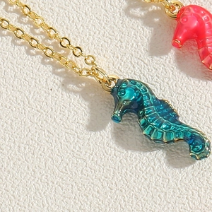 Detail of seahorse pendant with blue enamel gradient and gold-tone chain texture