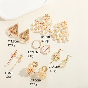 Boucles d'oreilles vintage fleurs dorées et perles avec strass sur plateau blanc