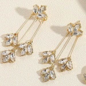 Detail von langen goldenen Ohrhängern mit Marquise-Kristallen im floralen Blattdesign