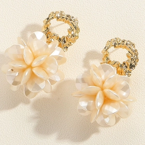 Détail de boucles d'oreilles fleurs vintage avec pétales crème et anneaux dorés