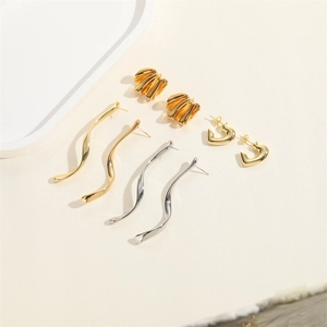 Modern polished metal earrings set with wavy dangles and heart-shaped studs in gold and silver